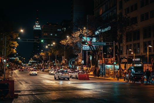 Explore the lively evening scene of Mexico City with bustling streets and colorful lights.